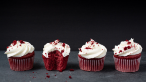 A plate of keto red velvet cupcakes topped with creamy sugar-free frosting and fresh berries—a perfect keto dessert recipe for beginners."